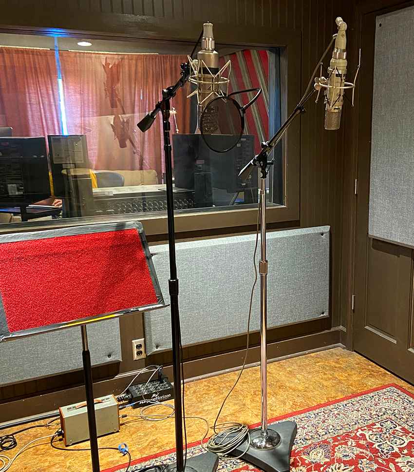A recording studio with two microphones perfect for singing lessons.